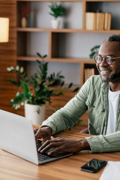 cheerful-confident-mature-african-american-businessman-in-glasses-and-casual-working-on-laptop-in.jpg